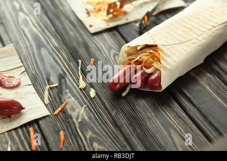 Geräucherte Wurst in pita Brot auf hölzernen Hintergrund Stockfoto