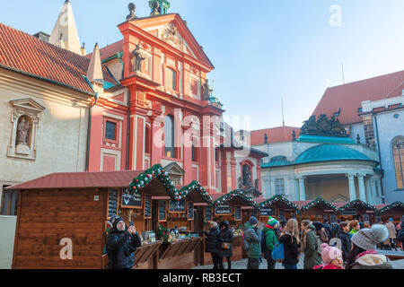 Touristen, die in Der beliebte Weihnachtsmarkt auf der Prager Burg in der Nähe von St George's Basilica. Stockfoto