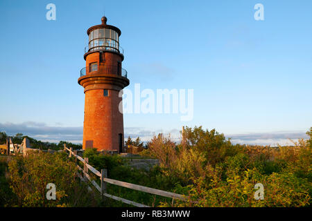 Holzzaun führt zu der große gemauerte Turm von aquinnah Leuchtturm, auch als Gay Kopf Licht, auf einen späten Sommer Tag auf Martha's Vineyard. Stockfoto