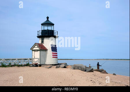 Fischerei vor der Sandstrand von Brant Point Leuchtturm auf Nantucket Island in Masssachusetts. Die Rundumleuchte ist in eine amerikanische Flagge umwickelt. Stockfoto