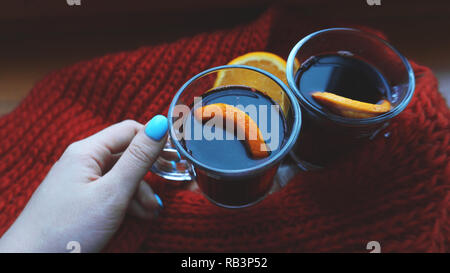 Frau mit Glühwein mit Gewürzen und Zitrusfrüchte in der Hand, in der Nähe Stockfoto