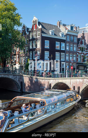Touristenboot auf den Grachten in Amsterdam, Niederlande Stockfoto