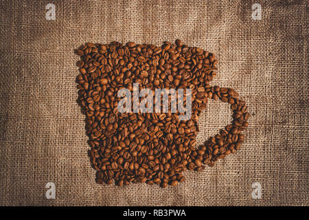 Bild einer Tasse Kaffee aus Bohnen auf dem Brett Stockfoto