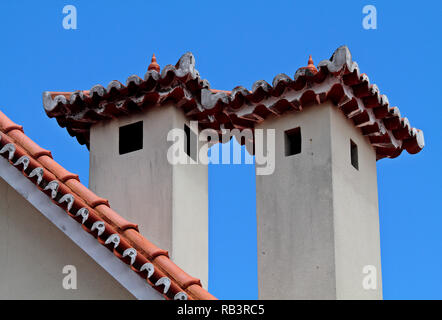 Zwei weiße dekorative Kamine mit roten Dachziegeln und taube Dekorationen Stockfoto
