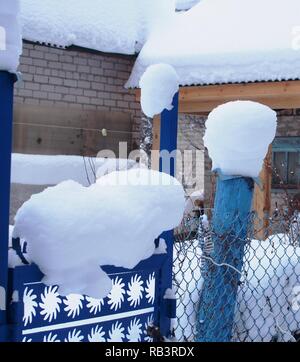 Schnee Kappen liegen auf dem Zaunpfosten. Nach einem heftigen Schneefall. Winterlandschaft. Stockfoto