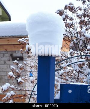 Schnee Kappen liegen auf dem Zaunpfosten. Nach einem heftigen Schneefall. Winterlandschaft. Stockfoto