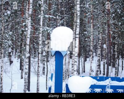 Schnee Kappen liegen auf dem Zaunpfosten. Nach einem heftigen Schneefall. Winterlandschaft. Stockfoto