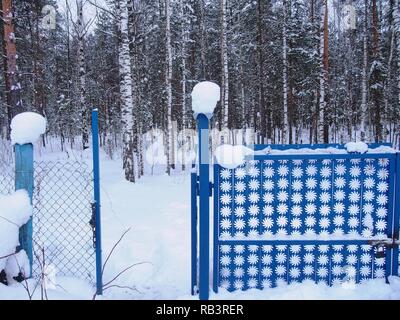 Schnee Kappen liegen auf dem Zaunpfosten. Nach einem heftigen Schneefall. Winterlandschaft. Stockfoto