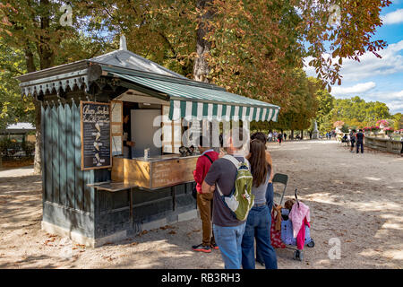 Eine Schlange von Menschen, die an einem Sommertag im Jardin du Luxembourg, Paris, Frankreich, an einem Erfrischungskioské Schlange stehen Stockfoto