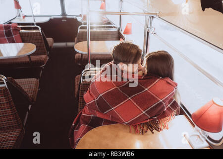 Liebevolle junge Paar im Winter in einem Cafe sitzen Stockfoto