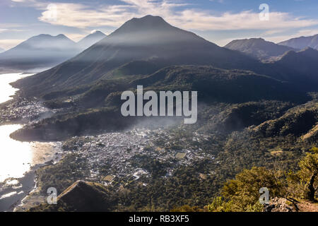 Blick vom Indischen Nase über Atitlan See, 3 Vulkane, San Juan La Laguna & San Pedro La Laguna kurz nach Sonnenaufgang im guatemaltekischen Hochland. Stockfoto