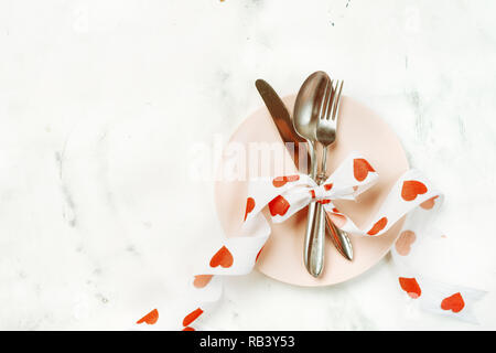 Festliche Tischdekoration mit Besteck und rosa Platte für Valentines Tag Stockfoto