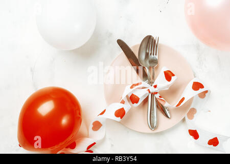 Festliche Tischdekoration mit Besteck und rosa Platte für Valentines Tag Stockfoto