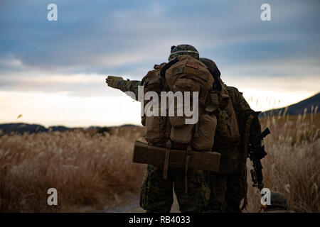 Us-Marines mit 2.Bataillon, 23 Marine Regiment, derzeit um die 3. Marine Division zugeordnet, die Route während der Übung Wald Licht 19.1, in Hijyudai Manöver, Japan, am Dez. 15, 2018 diskutieren. Dies ist das erste Mal in 13 Jahren, dass die Reserve Einheit 2/23 aktiv ist und zu den indopazifischen Region bereitgestellt. Sie werden mehrere bilaterale Übungen in verschiedenen Ländern durchführen, um die Bekämpfung der Bereitschaft zu verbessern und die internationalen Beziehungen zu stärken. (U.S. Marine Corps Foto von Lance Cpl. Christine Phelps) Stockfoto