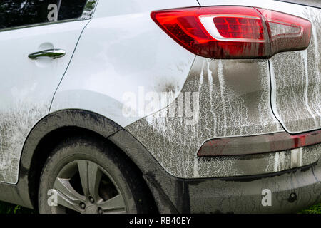 Rückansicht eines sehr schmutzig. Fragment einer schmutzigen SUV. Verschmutzte Scheinwerfer, Rad und Stoßfänger der Geländewagen mit Sumpf spritzer auf einer Seitenwand Stockfoto