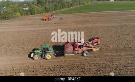 Kartoffeln ernten Maschine mit Traktor in Ackerland zur Ernte von Kartoffeln. Landmaschinen Ernte von Kartoffeln. Stockfoto