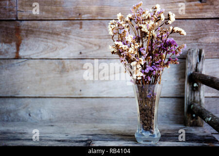 Glas Vase und trocken Blume auf Holztisch. Stockfoto