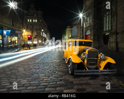 Schöne alte gelbe Auto auf gepflasterten Straße in der Nacht im mittelalterlichen Edinburgh Stockfoto