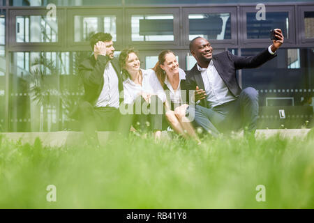 Team Business Leute, die einen selfie in der Pause im Sommer vor dem Büro Stockfoto