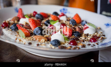 Bio Müsli und Joghurt zum Frühstück, zum Brunch mit frischen Erdbeeren und Blaubeeren, Muttern Stockfoto