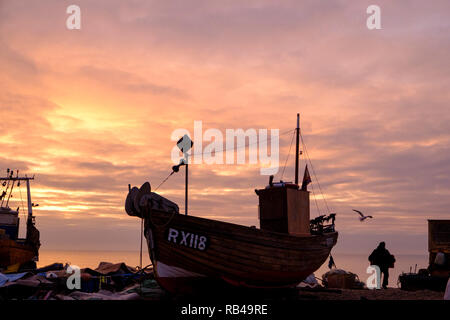 Hastings, East Sussex, UK. 7. Jan 2019. Sehr milden Start in den Tag bei Sonnenaufgang am Strand des Stade Fischer als Fischer ihre Boote laden. Hastings hat den größten Strand-Flotten in Europa. Stockfoto