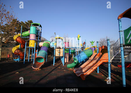 Bunte Kinder Spielplatz in einem Park im Winter, mit Kunststoff Folien und andere Elemente Stockfoto