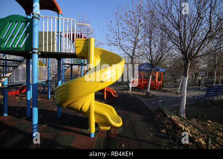 Bunte Kinder Spielplatz in einem Park im Winter, mit Kunststoff Folien und andere Elemente Stockfoto