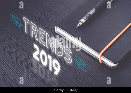 Nahaufnahme Blick von oben auf die Trends 2019 mit schwarz Notebook mit modernen mechanischen Bleistift auf Holz Tisch. Die Zukunft Prognosen neue Sache Stockfoto