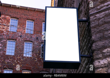 Leeren weißen Hinweistafel auf Straße der Stadt. Im Hintergrund Straße und Felsen. Mock up. Plakat auf der Straße. Der leere Raum für Text. Kopieren Sie Platz. Weiß isoliert Stockfoto