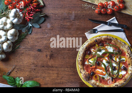 Ansicht von oben Hintergrund italienische neapolitanische Pizza mit Paprika, Oliven, Tomaten und Käse. frame Komposition mit Zutaten freier Platz für Text Stockfoto