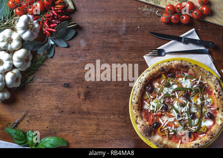 Ansicht von oben Hintergrund italienische neapolitanische Pizza mit Paprika, Oliven, Tomaten und Käse. frame Komposition mit Zutaten freier Platz für Text Stockfoto