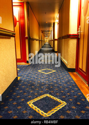 Sehr langen Korridor der Kreuzfahrt Schiff. Zimmer auf beiden Seiten. Langen Korridor mit geschlossenen Kabinen der Kreuzfahrtschiffe. Stockfoto