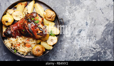 Eisbein auf hölzernen Oberfläche. Gebratene Schweinshaxe mit Kartoffeln Stockfoto