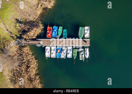 Luftbild von oben - kleine farbige Boote zu den hölzernen dock Tag See schöne günstig Stockfoto