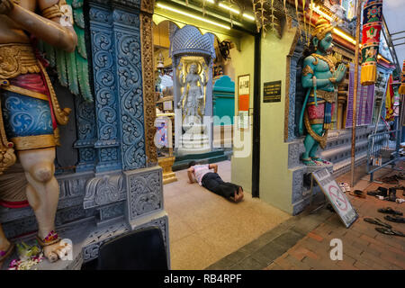 Ein Hindu Mann niederwerfen vor dem Idol in Sri Krishnan Tempel, Waterloo St., Bugis, Singapur, einen Tempel, der hinduistische Gott Krishna gewidmet Stockfoto