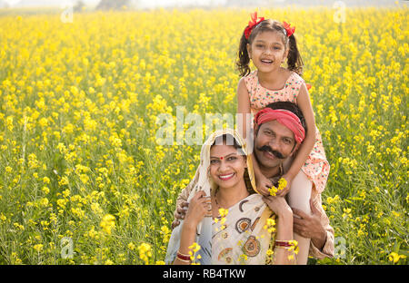 Portrait von Happy ländlichen indischen Familie in Raps landwirtschaftliches Feld Stockfoto