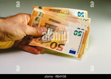 Mann Hand, die Haufen von 50 Euro Rechnungen Reichtum in einem Geschäft zu zeigen. Stockfoto