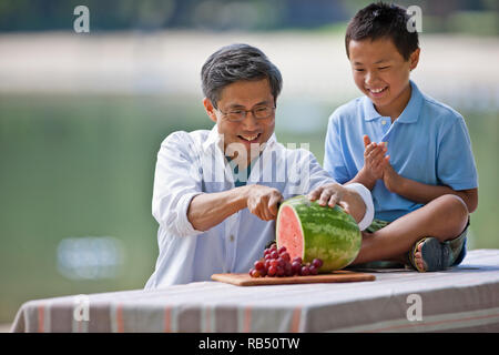 Gerne Vater und Sohn Wassermelone zusammen genießen. Stockfoto