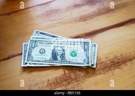 Ein kaukasischer Mann zählt sein Geld auf den Tisch. Stockfoto