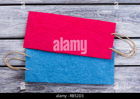 Zerknittertes Papier bunten Einkaufstaschen. Mockup von leeren Handwerk Pakete auf Holz- Hintergrund. Stockfoto