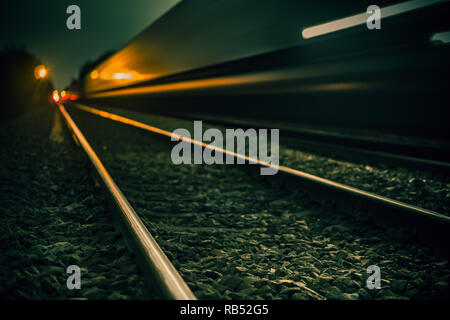 Ein Foto eines Güterzug vorbei während der kalten Nacht, bearbeitet ein kalter Winter mit einem blauen & grünen Ton zu haben Stockfoto
