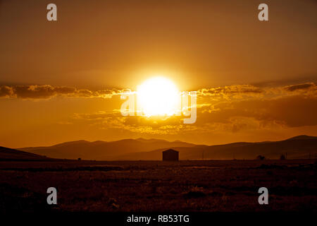 Feurigen Sonnenuntergang über dem kleinen Dorf Stockfoto