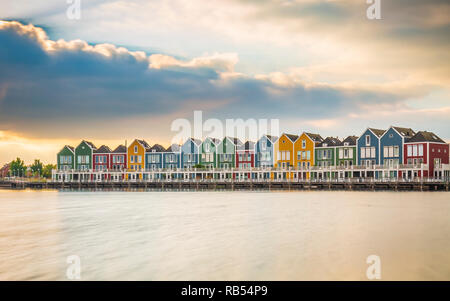 Niederländisch, modernen, farbenfrohen vinex Architektur Häuser am Wasser während der dramatischen und bewölkt, Sonnenuntergang. Houten, Utrecht. Stockfoto