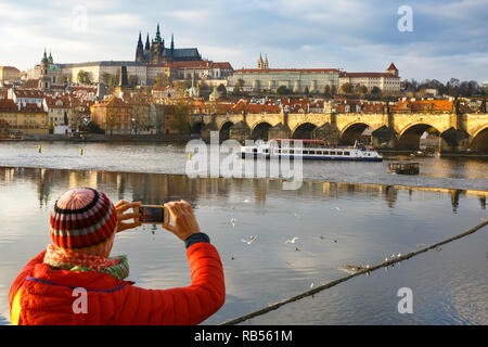 Touristen, die Bilder von Herbst Stadt Prag mit Charles Brücke über die Moldau und den Hradschin Burganlage. Reise, Urlaub, Sightseeing conc Stockfoto