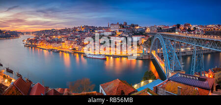 Porto, Portugal. Panorama-Stadtbild von Porto, Portugal mit der berühmten Luis-I-Brücke und dem Douro-Fluss bei dramatischem Sonnenuntergang. Stockfoto