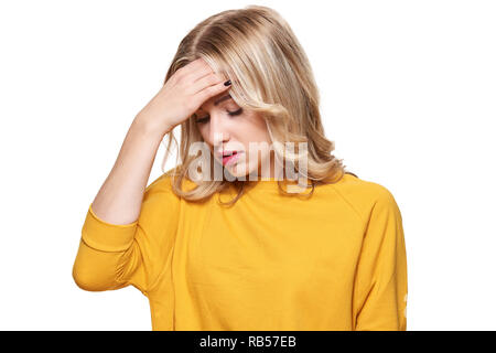 Erschöpft Junge weibliche In starke Spannung Kopfschmerzen betont. Gefühl Druck und Stress. Deprimiert Frau mit Kopf in den Händen Über weißen Hintergrund. Stockfoto