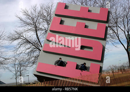 Junge Jungen klettern riesige Gummi-Stempel Skulptur in der Innenstadt von Cleveland, Ohio, USA Stockfoto