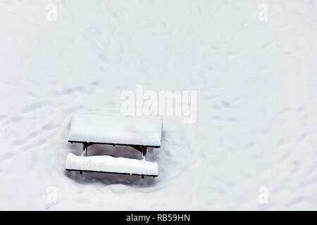 Holzbank Picknick Tisch in einem Park mit Schnee im Winter abgedeckt Stockfoto