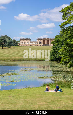 Ein junges Paar beim Picknick am See bei Stowe House Gardens, Buckinghamshire UK Stockfoto