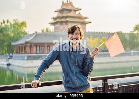 Genießen Sie Urlaub in China. Junger Mann mit nationalen chinesischen Flagge in der Verbotenen Stadt. Die Reise nach China. Kostenloses Visum Transit 72 Stunden, 144 Stunden in China Stockfoto